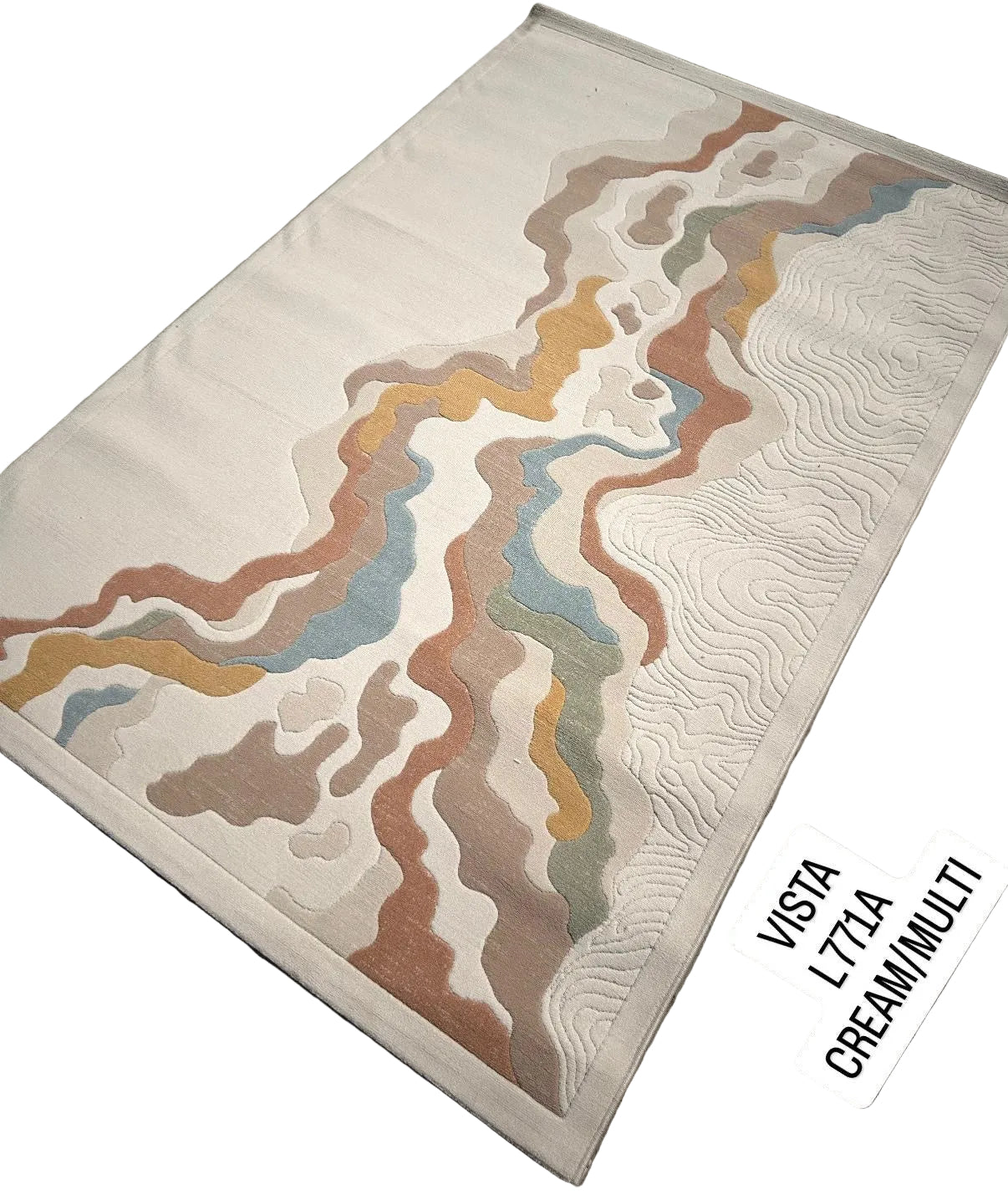 A rectangular cream-colored quilted rug with an abstract wavy pattern in muted brown, beige, blue, and orange tones, laid flat on a gray patterned floor. Two white stickers at the bottom right read 'VISTA L71A CREAM/MULTI'.