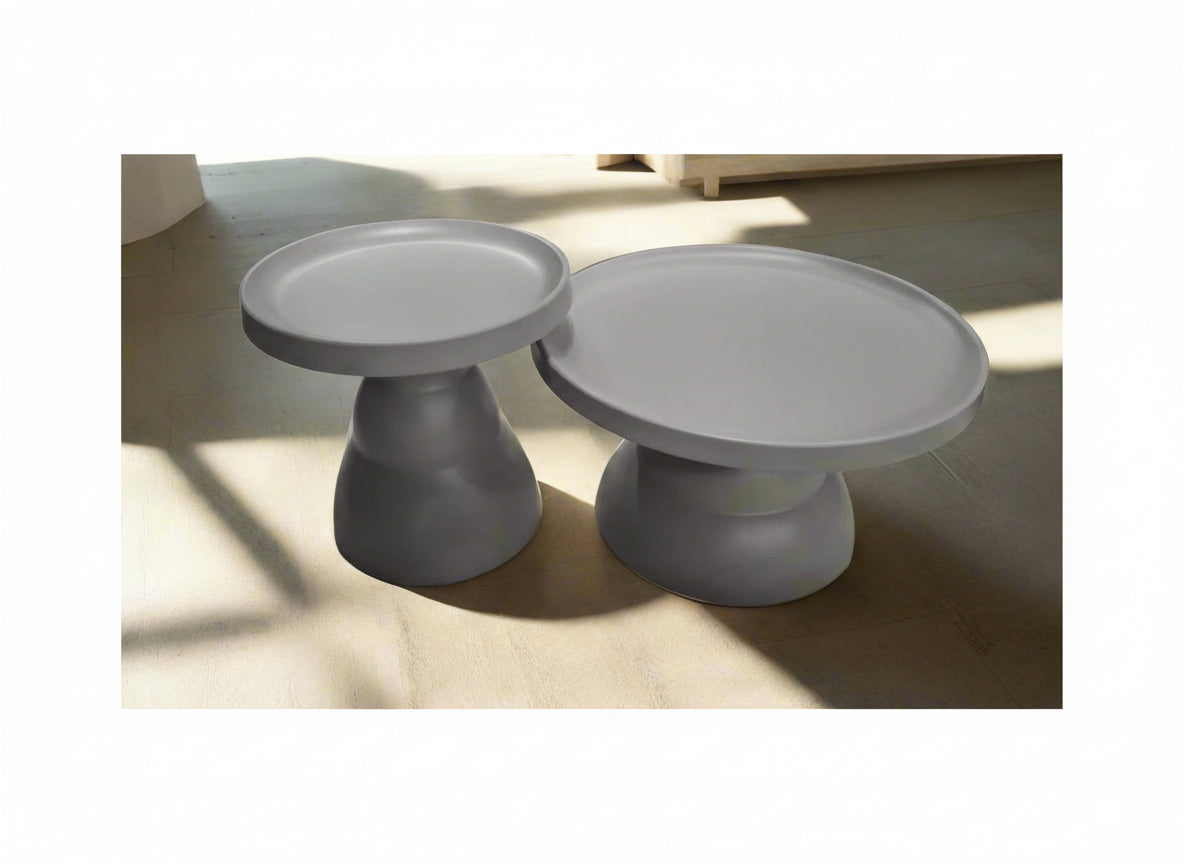 Two gray faux ceramic cake stands on a light wooden surface.